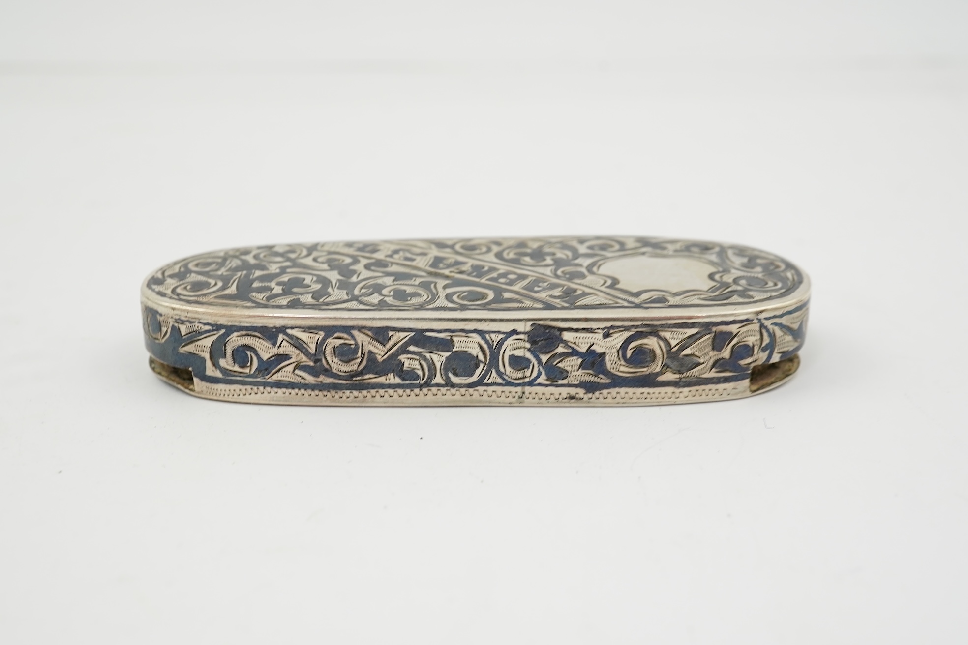 A 19th century Russian silver and niello coin case, of oval form, with Cyrillic inscription and three slide action coin compartments, unknown master, 76mm.